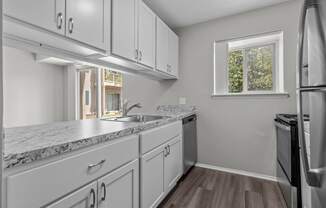 an empty kitchen with white cabinets and stainless steel appliances