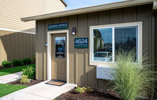 the front of a building with a door and a sign that reads lease office