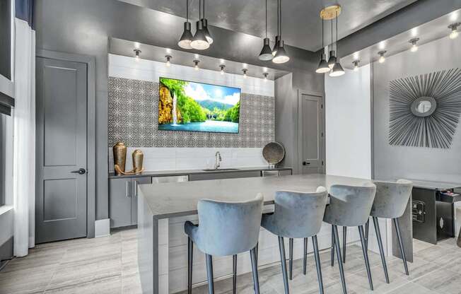 A modern kitchen with a large island and chairs.