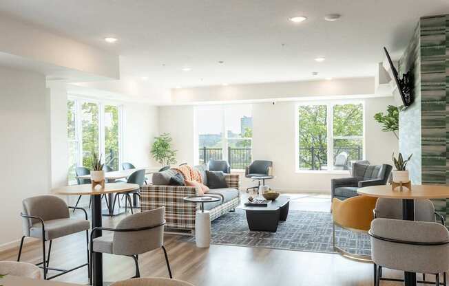 A living room with a couch, chairs, and a television.