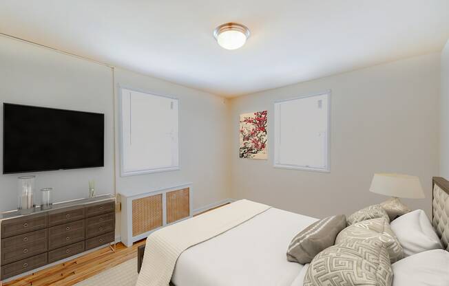 bedroom with bed, nightstands, and tv at garden village apartments in congress heights washington dc