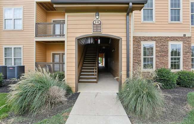 the entrance to an apartment building with stairs and a walkway