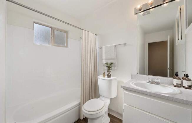 A white bathroom with a toilet, sink, and bathtub.