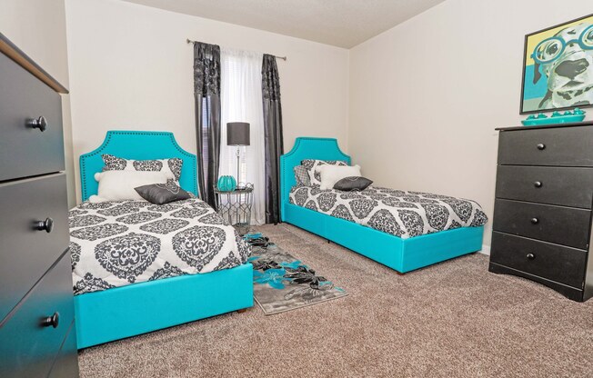 A room with two beds and a dresser at The Drake in Bossier City, LA