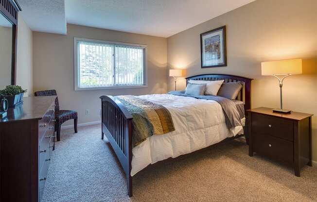 a bedroom with a bed and a dresser and a window