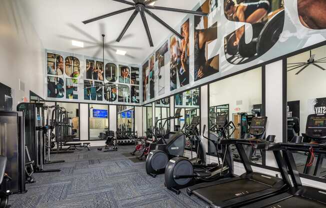 Gym with cardio equipment and posters on the wall