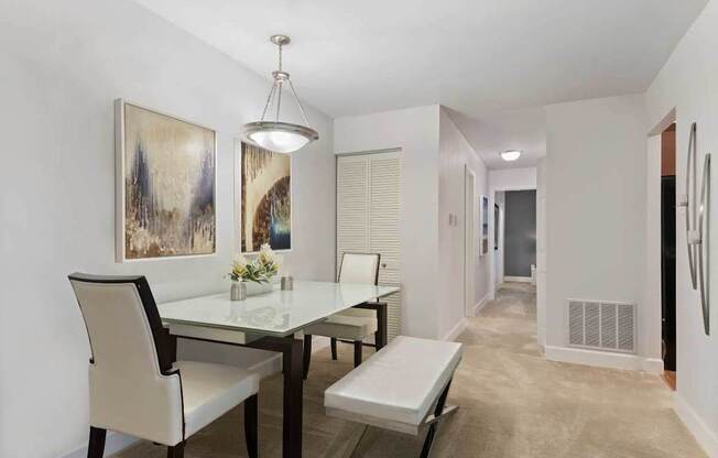 A dining room with a glass table and chairs.