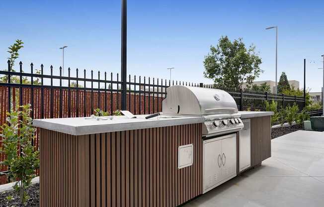 A modern outdoor kitchen with a grill and sink.