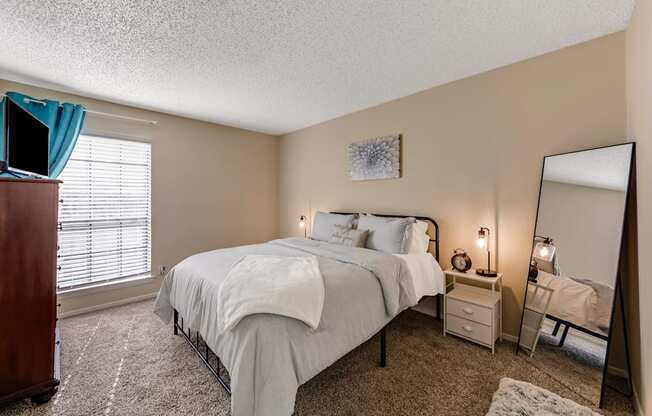 a bedroom with a bed and a dresser and a mirror