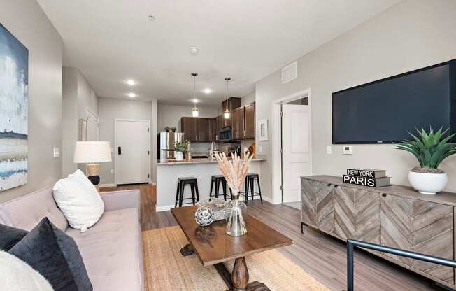 A living room with a couch, a coffee table, and a flat screen TV.