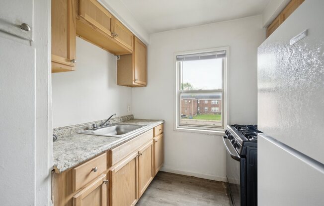 A kitchen with wooden cabinets and a white fridge.