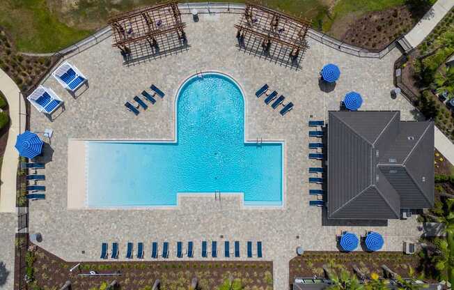 An aerial view of a pool surrounded by lounge chairs and umbrellas.