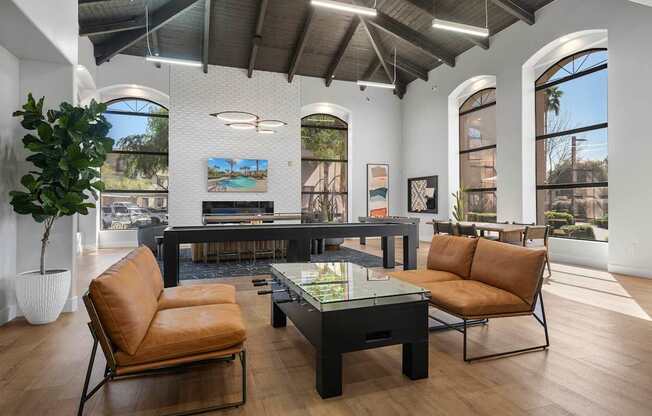 A living room with a brown leather chair and a glass table.