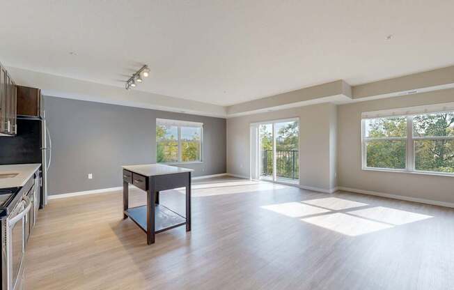 A spacious kitchen and dining area with wooden floors and large windows.