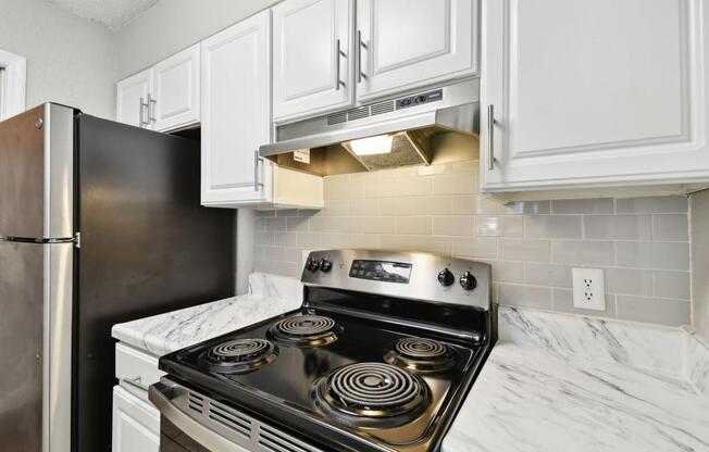 a kitchen with white cabinets and a stove and a refrigerator