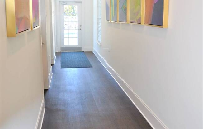 A hallway with a series of paintings on the wall.