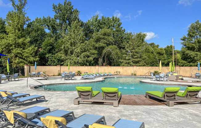 a pool with chairs and tables and a swimming pool with trees