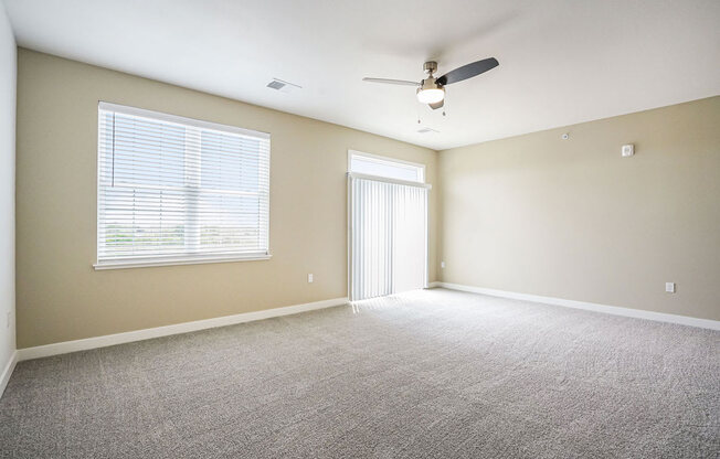 an empty room with a ceiling fan and a large window at Meadowbrooke Apartment Homes, Grand Rapids, MI, 49512