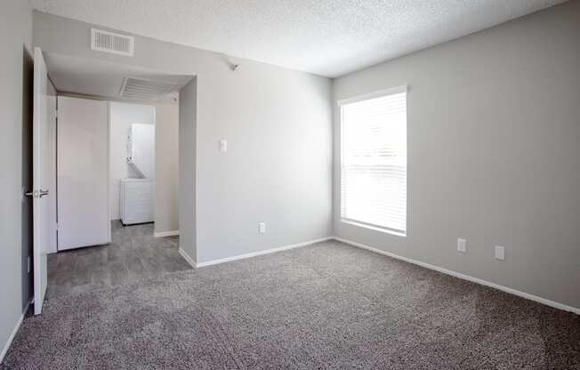 an empty living room with carpet and a large window