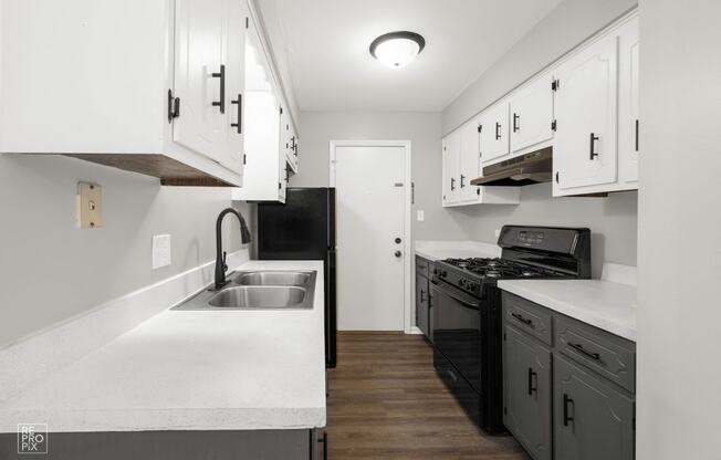 a renovated kitchen with white cabinets and black appliances