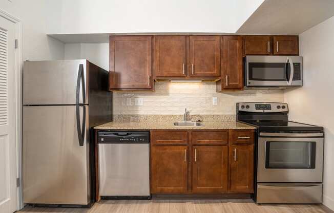 a kitchen with wooden cabinets and stainless steel appliances