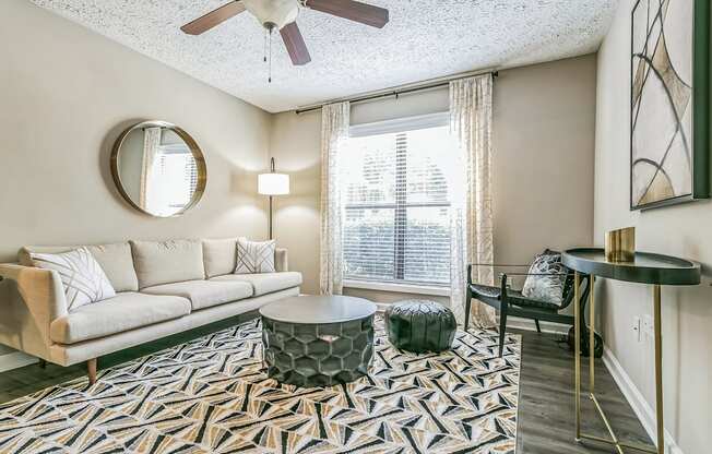 a living room with a couch and a chair and a window