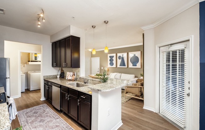 A kitchen with a white island and dark brown cabinets.