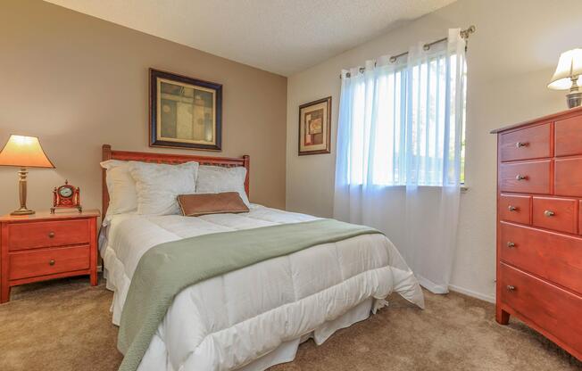 a bedroom with a bed and desk in a hotel room