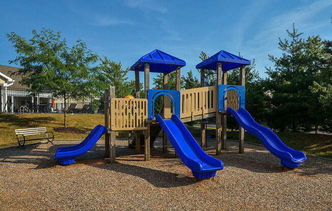 a playground with slides and benches in a park