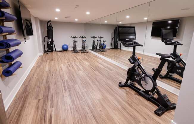 a gym with cardio machines and weights on a wooden floor