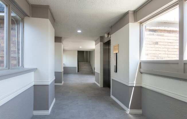 This is a photo of an elevatorin an open air hallway with new tile in the 450 square foot efficiency apartment at Cambridge Court Apartments in Dallas, TX.