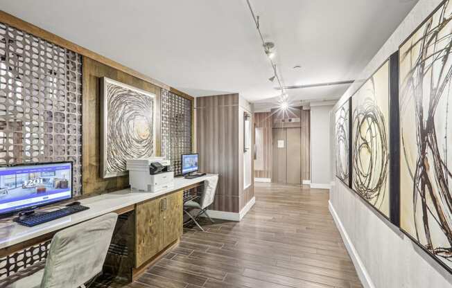 a home office with two computers on a desk and a wood floor