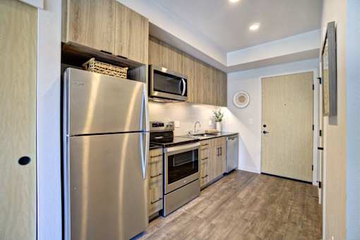 A modern kitchen with stainless steel appliances and wooden cabinets.