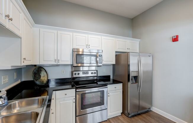 a kitchen with stainless steel appliances and white cabinets