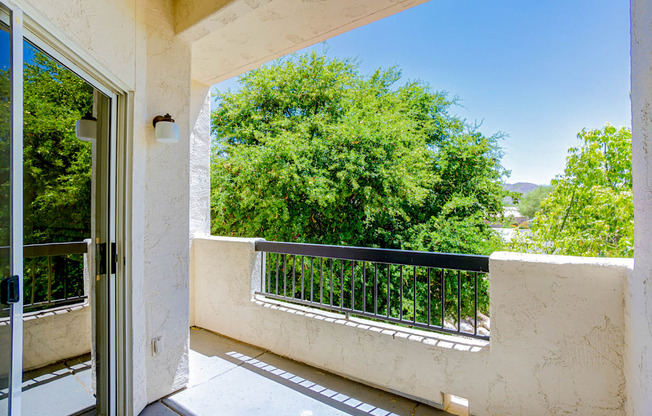 A balcony with a black railing and a glass door.
