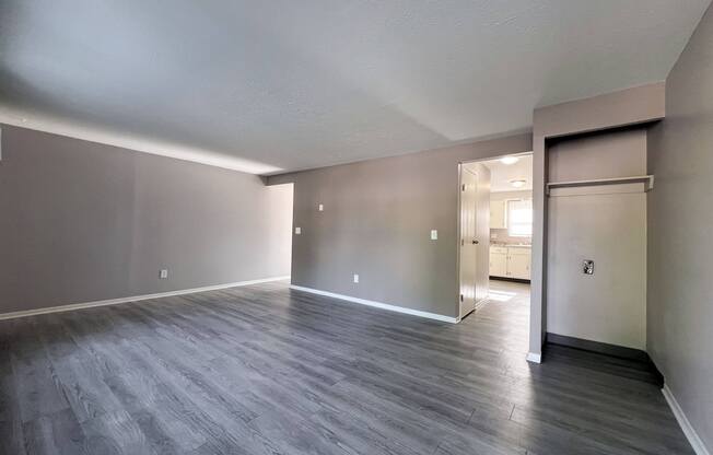 the living room of an empty apartment with wood flooring