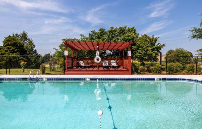 the pool is decorated with a swing set and a gazebo in front