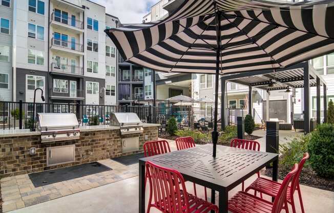 a patio with an umbrella and a table with chairs