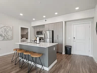A kitchen with a bar stool and a counter.