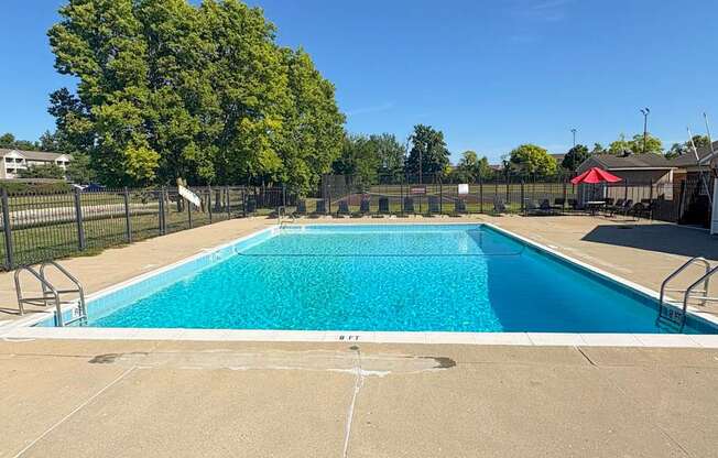 A large outdoor swimming pool surrounded by a fence.