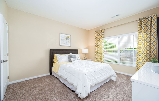 a bedroom with a bed and a large window