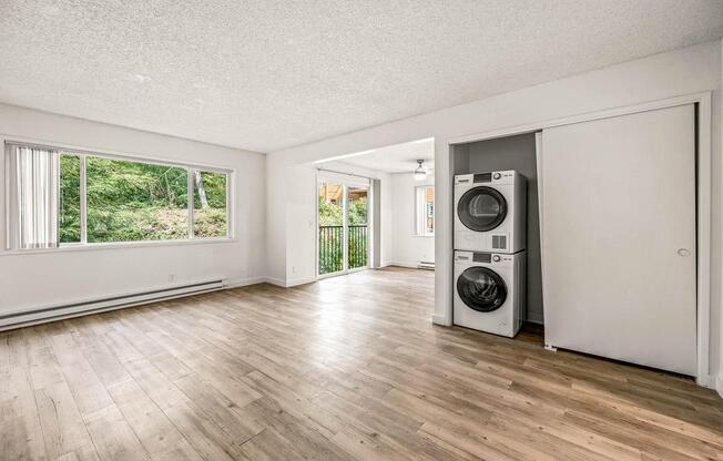 an empty living room with a washer and dryer