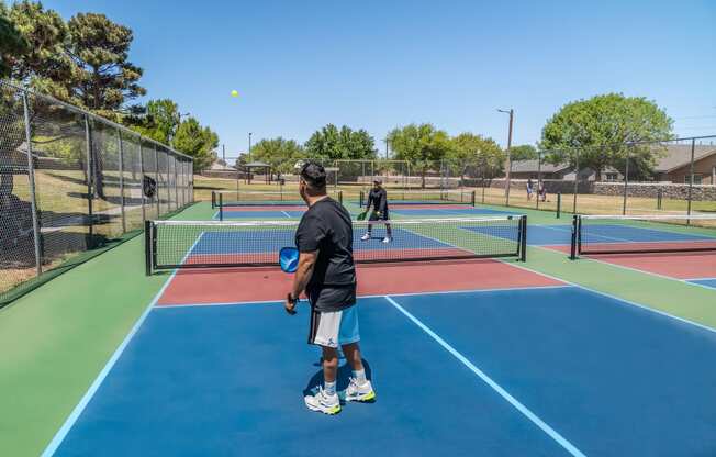 people playing tennis on a tennis court