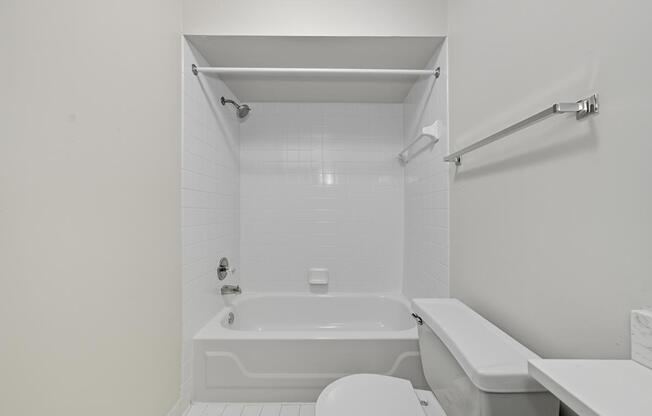 A white bathroom with a toilet, sink, and bathtub.