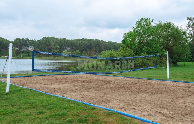 a volleyball court with a lake in the background
