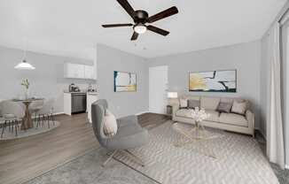 a living room with a couch and a chair and a ceiling fan