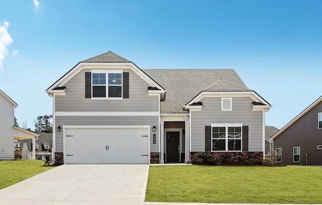 A two-story house with a garage and a driveway.