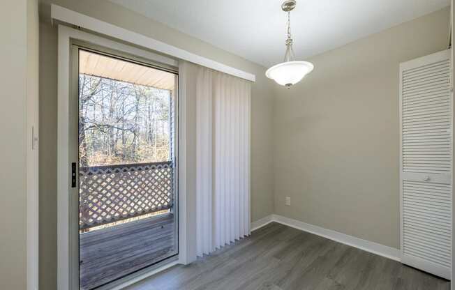 an empty living room with a large window and a wooden floor