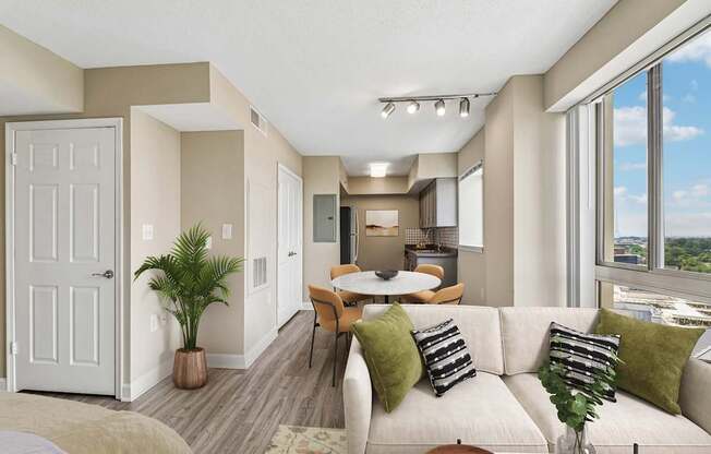 A well-lit living room with a couch, chairs, and a dining table.