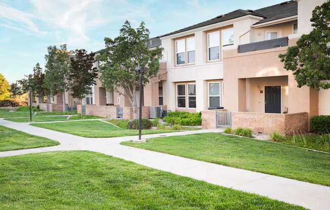 A row of houses with a white pathway in front.